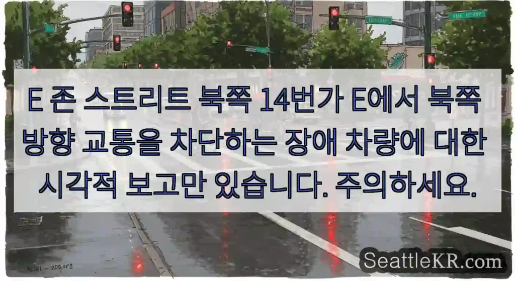 E 존 스트리트 북쪽 14번가 E에서 북쪽 방향 교통을 차단하는 장애 차량에 대한 시각적